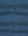 Men's long-sleeve button-up shirt in navy with a pin dot pattern and contrasting buttons. Features branding.