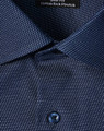 A navy blue men's button-up shirt featuring a pin dot pattern and a logo on the collar.