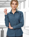 A teal button-up shirt for women with a pin dot pattern and long sleeves, featuring a logo on the chest.