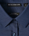 Ladies' pin dot stretch long sleeve shirt in navy with a button closure, featuring a logo label inside the collar.