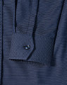 A navy blue pin dot stretch long sleeve shirt with a buttoned cuff and a branded logo.