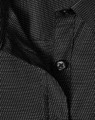 A close-up of a black ladies' button-up shirt with a pin dot pattern and a visible button.