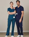 Two individuals wearing solid colour scrub pants—one in teal and the other in navy—standing side by side.