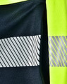 A navy jumper with reflective stripes and high visibility yellow accents, featuring a logo.