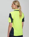 A woman wearing a high-visibility yellow and navy safety polo shirt, featuring a logo on the chest and back.