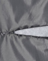 A close-up of a grey quilted fabric featuring a zippered section and a soft, light grey lining.