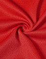 A close-up of red fabric with a textured, lightweight appearance suitable for performance wear.