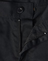 A close-up of black unisex utility stretch cargo work pants, featuring a button and zip closure.