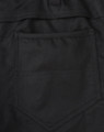 A close-up of black cotton stretch ripstop work pants, featuring a back pocket design and fabric texture.