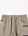 Unisex cotton stretch drill short work shorts in beige with an elastic waistband and multiple pockets.