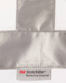 A reflective silver strip on a white fabric with a label for 3M Scotchlite reflective material.