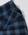 A unisex flannel plaid shirt in dark blue tones, featuring button-up closure and a visible logo.