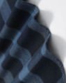 A close-up of a navy blue and black plaid flannel fabric, showcasing its soft texture and pattern.