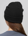 A black beanie made from rPET, displayed from the back on a model with long hair. It features a logo.