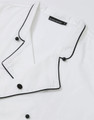 A white unisex executive chef jacket with black piping and buttons, featuring a branded label.