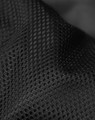 A close-up of black mesh fabric with a textured pattern, showcasing its breathable design and material quality.