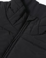 A black sustainable insulated puffer vest with a 3D cut and a zippered closure, featuring a logo.