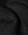 A close-up of black fabric, showing a soft, textured surface with fine details. The material appears sustainable and durable.
