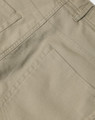 A close-up of khaki ladies' chino pants showcasing detailed stitching and pocket design. The pants have branding present.