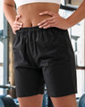 Unisex black mercerised cotton shorts with an elastic waistband, featured in a gym setting.