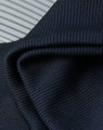 A close-up of textured, dark navy fabric with a ribbed pattern, showcasing its soft and flexible quality.