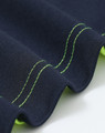 A close-up of a navy polo shirt with bright green stitching and detailing along the edges. It features a logo.