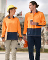 Two people walk side by side, wearing a hi-vis orange and navy blue long-sleeve polo shirt and safety gear.
