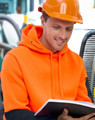 A bright orange and black water-resistant fleece hoodie with a hood, worn by a person in safety gear, reading a book.