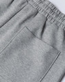 A close-up of grey unisex sweatpants featuring an elastic waistband and a back pocket.