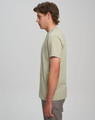 A light green men’s premium cotton t-shirt displayed on a model, viewed from the side. The shirt has a logo on it.
