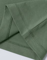 A green ladies' premium cotton short-sleeve tee shirt, featuring neat stitching at the sleeves. There is a logo present.