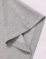 A close-up of a grey long-sleeve cotton tee shirt, featuring a stitched hem and smooth fabric texture.