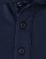 A close-up of a navy blue polo shirt featuring a button placket and a small logo.