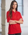 A red unisex traditional polo shirt features a collar and short sleeves, displayed on a model in a bright setting.