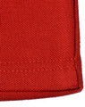 A close-up of a red poly/cotton pique knit fabric, showcasing the texture and stitching of a long sleeve polo shirt.