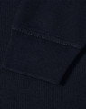 A close-up view of the cuff of a navy blue polo shirt featuring a ribbed design and a logo.