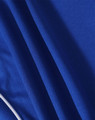 A close-up of a blue polo shirt made from textured fabric with contrasting stripes and a logo.