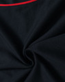 A close-up view of a black polo shirt featuring a red accent and a logo. The fabric appears soft and smooth.