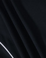 A close-up of a black polo shirt fabric with textured pattern and a contrasting white trim.