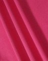A close-up of textured fabric in a vibrant pink colour, showcasing its structure and weave.
