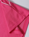A close-up of a pink polo shirt featuring short sleeves and contrasting trim. The shirt includes a logo.