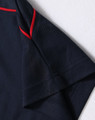 A navy polo shirt featuring a red trim. The image focuses on the shirt's collar and sleeve detail.