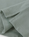 A close-up view of a light green men's cotton stretch polo shirt, highlighting the fabric and stitching details.
