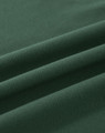 A close-up view of soft, dark green cotton fabric, featuring gentle folds and a smooth texture.