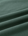 A close-up of a folded green cotton fabric, showcasing its soft texture and stretchability.