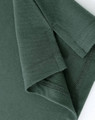 A close-up of a ladies cotton stretch polo shirt in dark green, showing the cuff and stitching details.