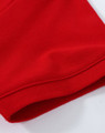 A close-up of a red cotton stretch polo shirt, highlighting the fabric and hem detail. The shirt features a logo.