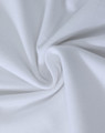 A close-up view of soft, white cotton fabric, showcasing a smooth and stretchy texture.