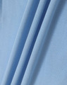 A close-up of light blue fabric, showcasing the texture and folds of a polo shirt material.