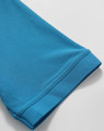 A close-up of a turquoise polo shirt sleeve, showcasing its textured fabric and cuff detail.